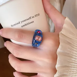 Detailansicht eines blauen Harzrings für den Zeigefinger mit bunten Strasssteinen