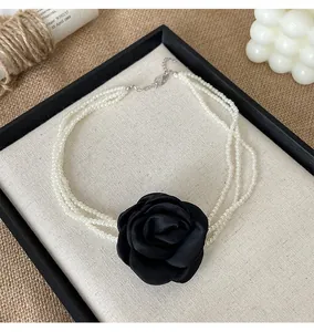 Elegante mehrreihige weiße Perlen-Choker-Halskette mit einer großen schwarzen Stoffrose.