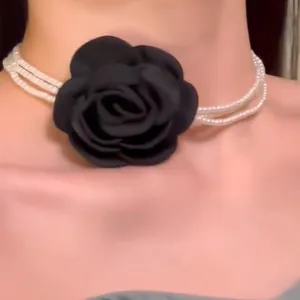 Detailansicht eines mehrlagigen Perlen-Chokers mit eleganter schwarzer Stoffrose