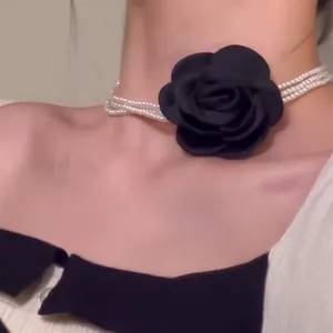Detailansicht eines eleganten mehrreihigen Perlen-Chokers mit einer schwarzen Stoffrose.