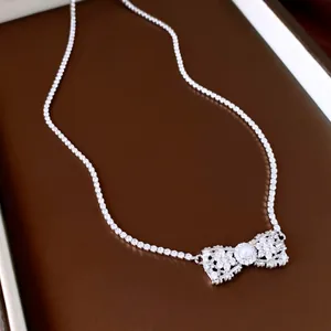 Gros plan d'un collier nœud élégant orné de zircons scintillants et d'une perle centrale.