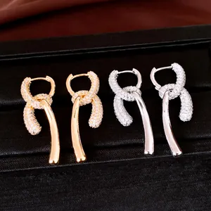 Close-up of gold and silver 18k plated dangle earrings with sparkling cubic zirconia