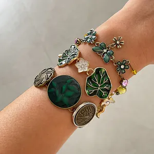 Detailed view of vintage flower and leaf bracelets with green resin and rhinestones