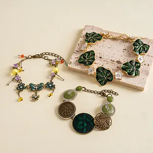 Macro detail of vintage-style enamel bracelets with leaf and flower charms