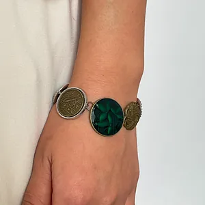 Close-up of a vintage resin bracelet with floral and leaf motifs worn on the wrist