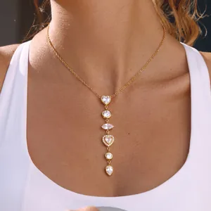 Elegant gold stainless steel necklace with sparkling heart and teardrop CZ pendants on model