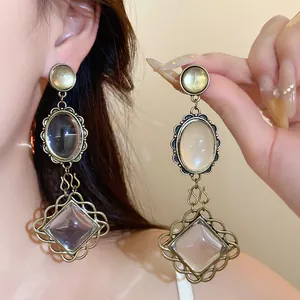 Gros plan de boucles d'oreilles vintage en bronze avec pendentifs ovales et de dentelle