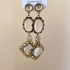 Gros plan de boucles d'oreilles vintage en bronze avec pendentifs ovales et losanges