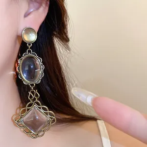 Gros plan détaillé de boucles d'oreilles vintage en dentelle métallique et résine