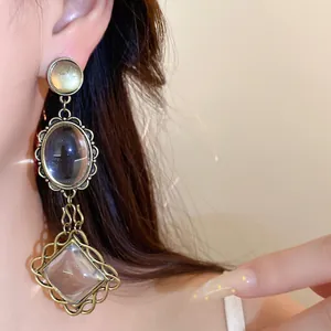 Vue détaillée de boucles d'oreilles pendantes vintage en bronze avec bords en dentelle