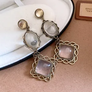 Vue détaillée de boucles d'oreilles vintage en métal avec pierres ovales et losanges