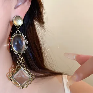 Gros plan de boucles d'oreilles vintage en or avec pierres ovales et losanges claires