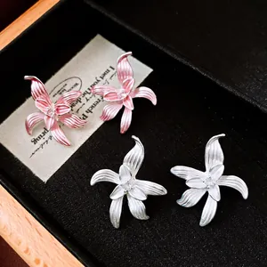 Detailansicht von zarten Emaille-Blumenohrsteckern mit schimmernden Zirkonia-Mitten.