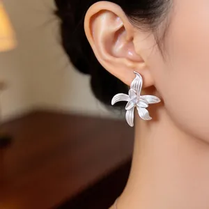 Detailansicht der mattsilbernen strukturierten Blumenohrstecker mit Zirkonia-Mitte