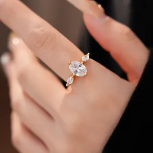 Nahaufnahme eines 18 Karat vergoldeten offenen Rings mit ovalem Zirkon am Finger.