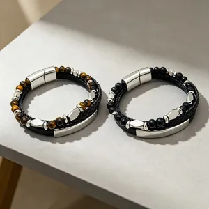 Gros plan de bracelets pour hommes en œil de tigre, onyx et cuir avec fermoirs magnétiques.
