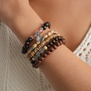 Close-up view of a five-piece bohemian wooden beaded elastic bracelet set on a wrist
