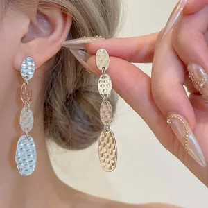 Boucles d'oreilles élégantes à pampilles ovales martelées avec texture argentée chic.