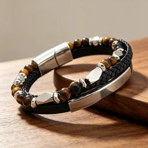 Gros plan d'un bracelet pour homme en œil de tigre et cuir noir avec fermoir magnétique en acier.