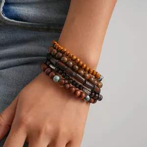 Detail showing a 5-piece set of ethnic wooden beaded stretch bracelets on a wrist.