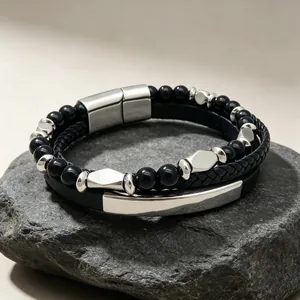 Vue détaillée d'un bracelet homme multicouche avec perles noires et barre en acier