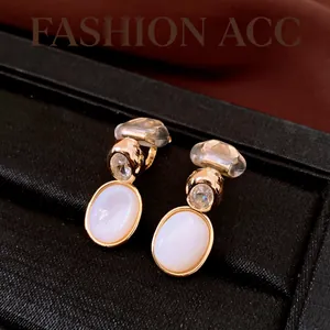 Vue détaillée des clips d'oreilles vintage en plaqué or 18 carats, zircon et nacre