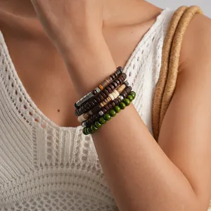 Close-up detail of 5-piece ethnic style wooden beaded elastic bracelet set worn on wrist