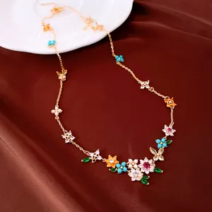 Detailed view of an 18k gold plated necklace with colorful zirconia flowers and butterflies.