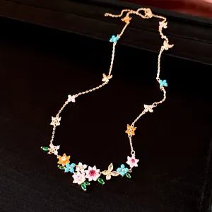 Close-up of 18k gold plated necklace with colorful zirconia flowers and butterflies