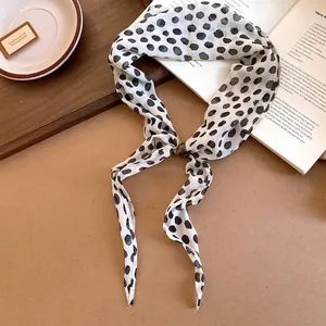 Vue détaillée de l'écharpe vintage à pois noirs avec fermeture à anneau de perles