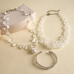 Chic glass bead jewelry set featuring pearl pendant necklace and crystal cuff on cream backdrop