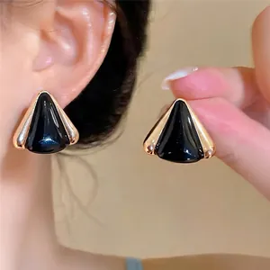Elegantes pendientes de botón triangulares de esmalte negro con acabado dorado