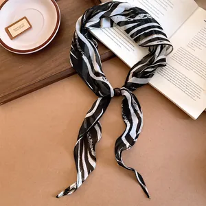 Détail d'un foulard en soie vintage à motif zèbre avec un curseur d'anneau en perles décoratif