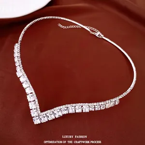Elegante V-förmige Halskette mit quadratischen Zirkonia auf braunem Satinhintergrund