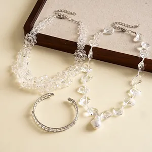 Collection of clear glass bead necklaces and crystal cuff bracelet on display board