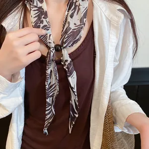 Gros plan d'un foulard en soie à imprimé floral vintage avec perle noire