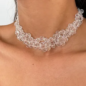 Detailed close-up view of a clear faceted glass bead choker necklace worn on model neck