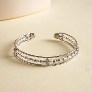 Elegant silver-toned open cuff bracelet detailed with faceted clear glass beads.