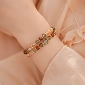 Primer plano de pulseras de cuentas en capas con vidrio y ojo de tigre estilo Maillard