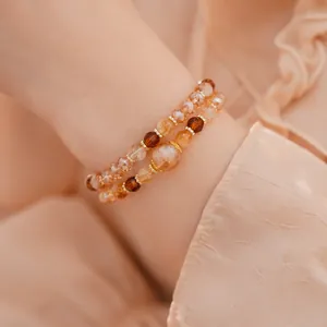Vista detallada de pulseras de cuentas de vidrio y ojo de tigre en una muñeca real