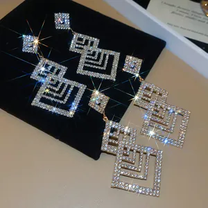 Elegante geometrische hohle Ohrhänger mit funkelnden Strasssteinen für das Bankett.
