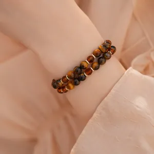 Primer plano de pulsera de doble capa con ojo de tigre y cuentas de vidrio