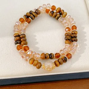 Primer plano de una pulsera de doble capa con piedras ojo de tigre y cuentas de vidrio tallado