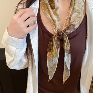 Gros plan d'un foulard en mousseline à fleurs vintage avec un détail de perle élégant