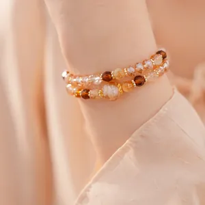 Primer plano de la pulsera de doble capa con cuentas de vidrio ámbar y ojo de tigre
