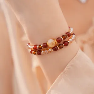 Primer plano de elegantes pulseras de cuentas en capas con cuentas de vidrio facetado.