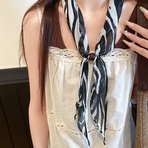 Détail d'un foulard en soie à imprimé zèbre vintage avec une boucle en perles