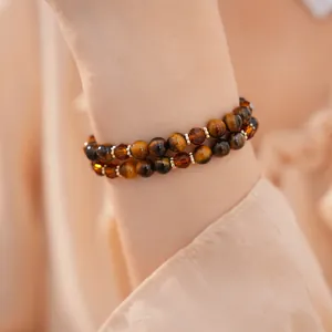 Vista detallada de una pulsera de doble capa de ojo de tigre y cuentas de vidrio