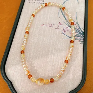 Primer plano de cuentas de vidrio ámbar y transparentes en una pulsera de lujo