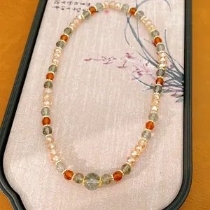 Elegante collar estilo Maillard con cuentas de vidrio y piedras de ojo de tigre en soporte.